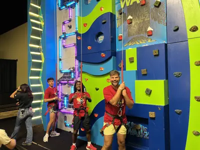 Children posing by a climbing wall
