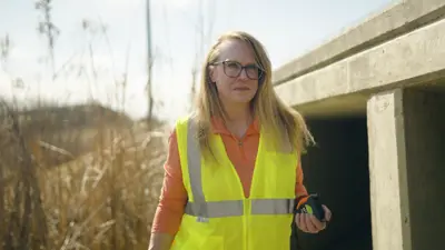 Stormwater Program Manager Kathy Roecker wears a yellow vest while working in the field. 